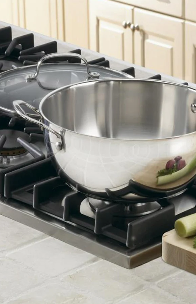 Angled view of Chef’s Classic Stainless 5.5 Quart Multi-Purpose Pan showcasing its mirror finish on a gas stovetop