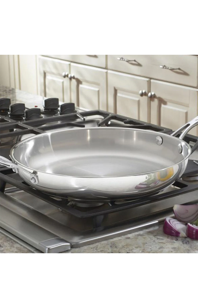 Angled view of Chef’s Classic 12-inch Skillet with Helper Handle showcasing polished stainless steel construction on a stovetop