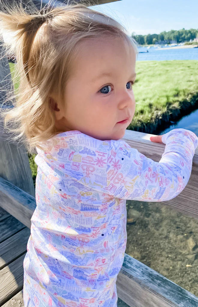 Back view of Rhode Island two-piece kids pajamas showing hand-drawn pastel print on a toddler by a dock