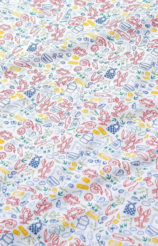 Close-up of Baby Zip Onesie showing clam bake lobster and shell print on white pima cotton