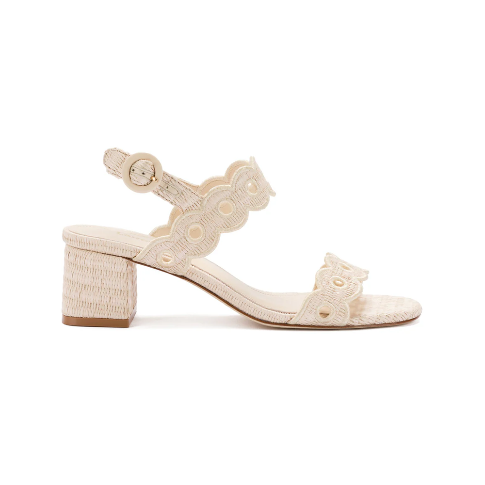Side view of the Florence Broderie sandal in natural raffia showcasing a block heel and scalloped straps on white