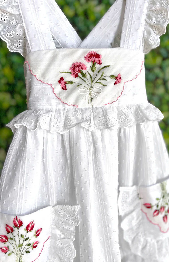 Close-up of Heirloom Handkerchief Dress in Red Rose Bouquet, 2T showcasing floral handkerchief appliqué with leafy background