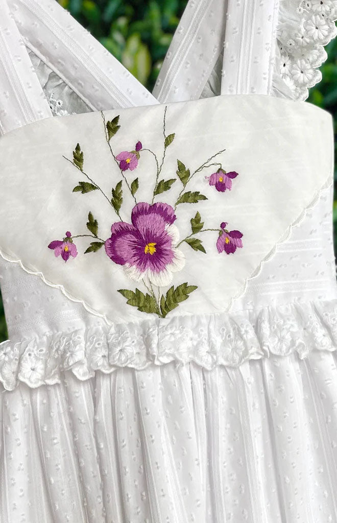 Heirloom Handkerchief Dress front close-up showing purple embroidered handkerchief applique, dotted Swiss fabric and eyelet ruffle