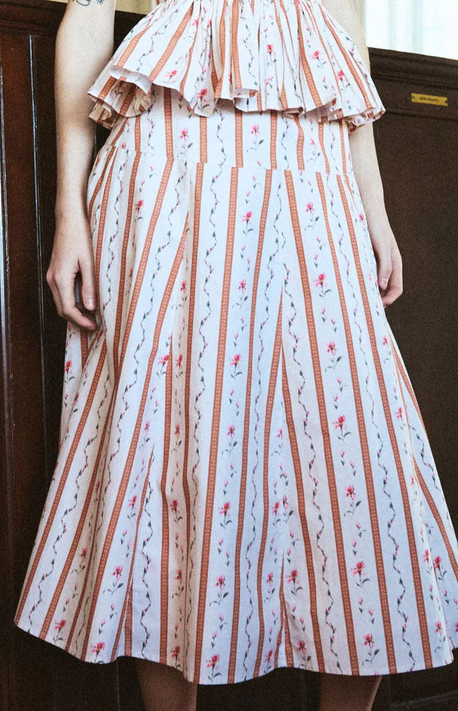 Front view of Justine Skirt in Cherie showcasing high-waisted A-line midi silhouette and vertical floral stripes against wooden background