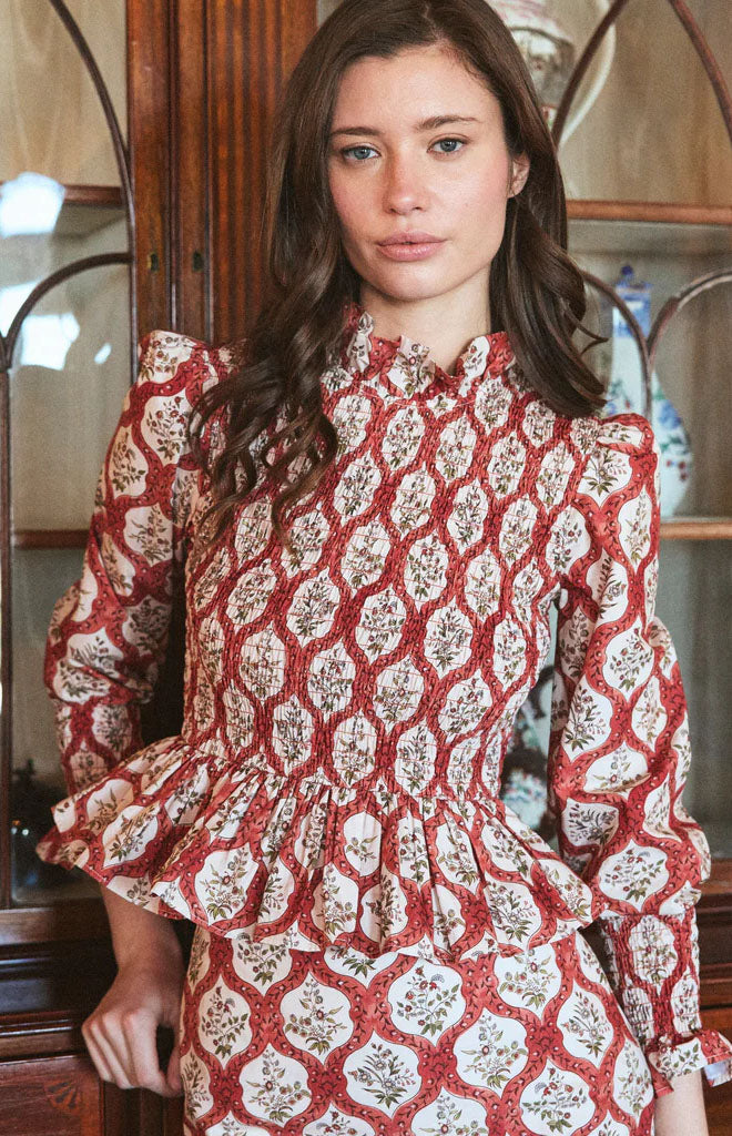 Front view of Molly Top in Saffron Trellis on model showcasing smocked bodice, ruffled peplum and puff sleeves