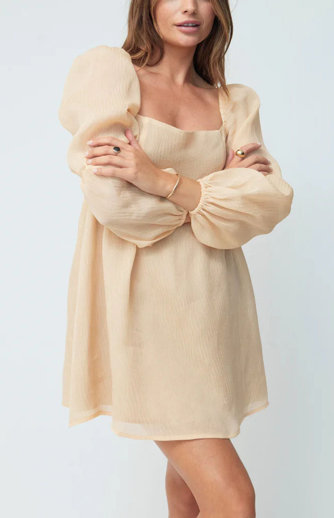 Front of The Kate Dress in Ballerina showing square neckline, puff sleeves, empire waist and mini hem on light background