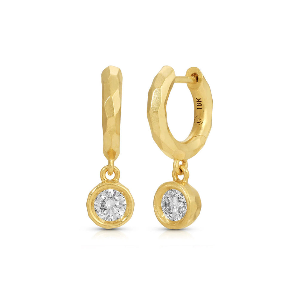 Front view of Hidden Gems round diamond drop hoops showing 18K yellow gold hoops and dangling bezel-set diamonds on white