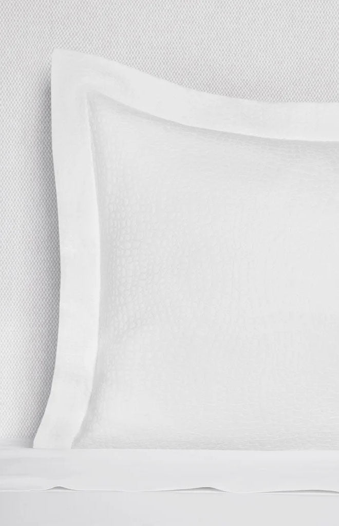 Close-up front of Cobblestones sham showcasing jacquard mosaic texture and narrow flange on white bedding background