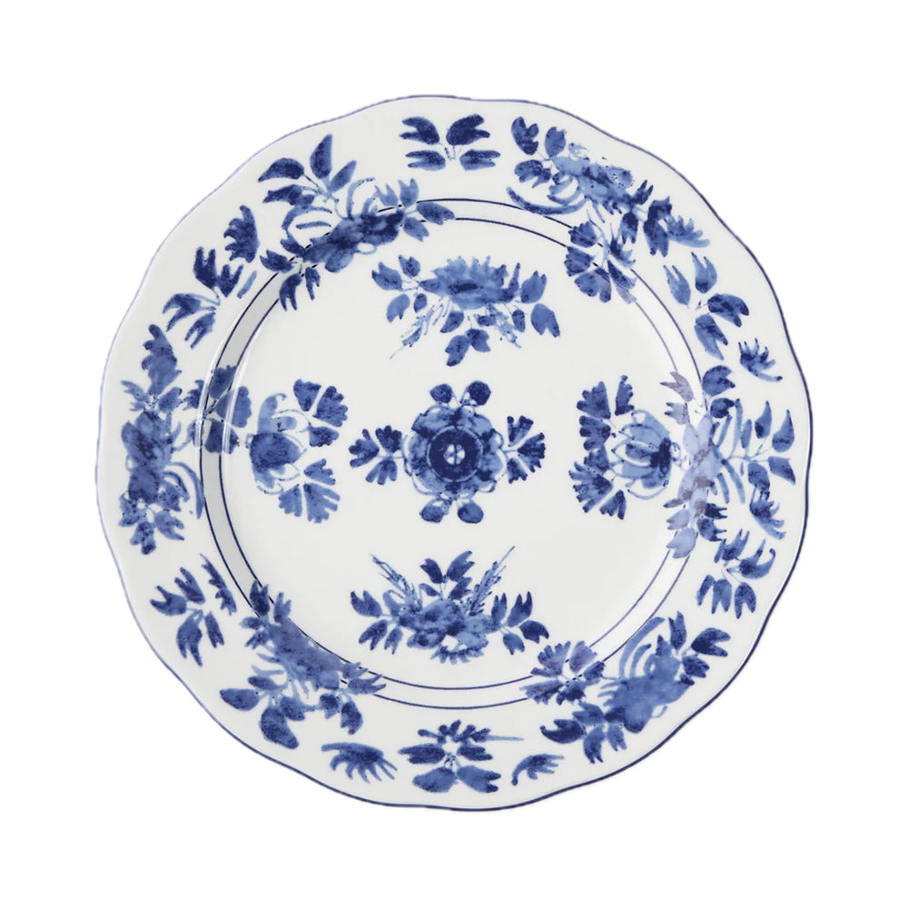 Top-down view of Gloria porcelain dinner plate showcasing blue watercolor floral pattern and scalloped edge on white background