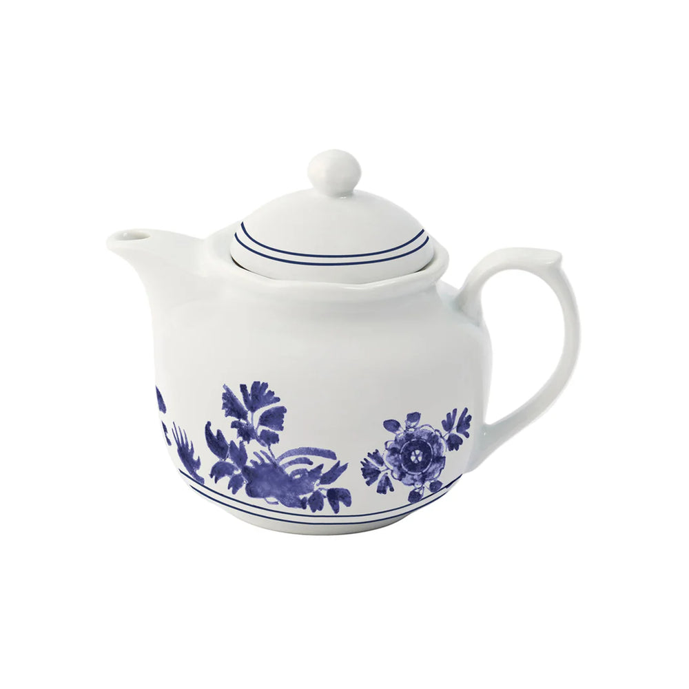 Three quarter view of Gloria porcelain teapot with blue floral motif, double rim stripes, and lid knob on white background
