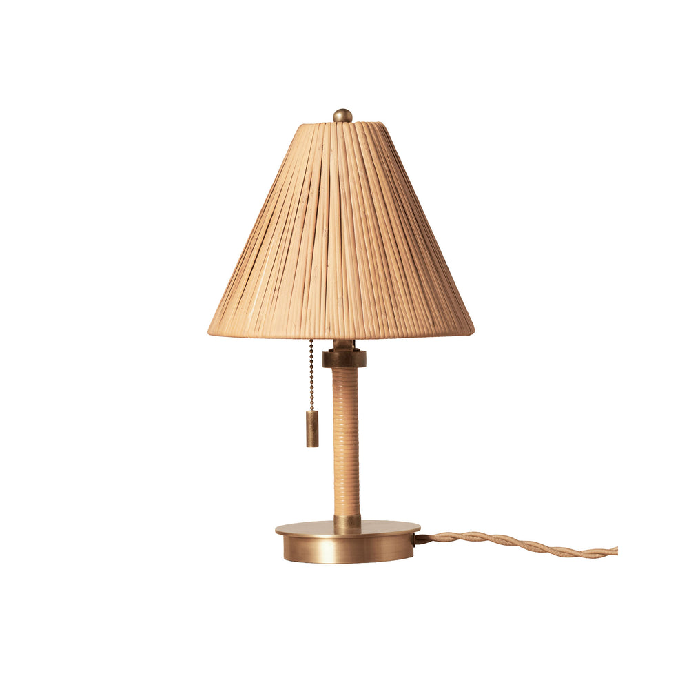 Front view of Delphine mini table lamp showcasing woven rattan shade, rattan stem and brass base on white background
