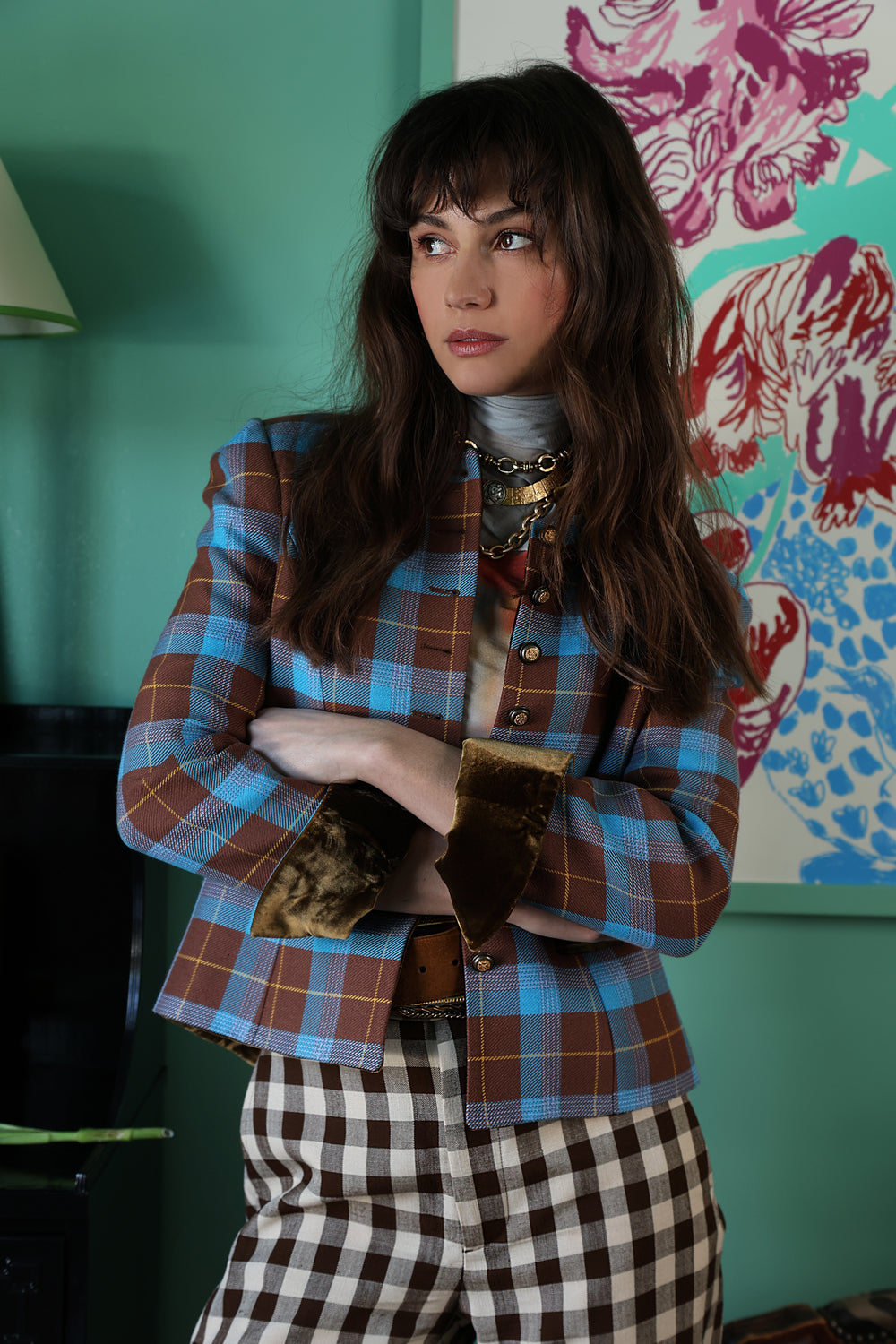Three-quarter view of Sanoë Annabelle Terra plaid jacket on model showing blue-and-brown checks and velvet cuff detail in teal interior
