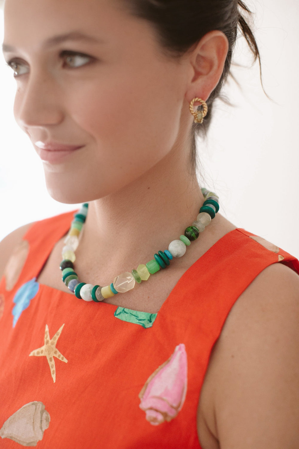 Close-up of Ocean Wanderer Necklace on model showing mixed green and aqua gemstone beads and gold-plated hook clasp