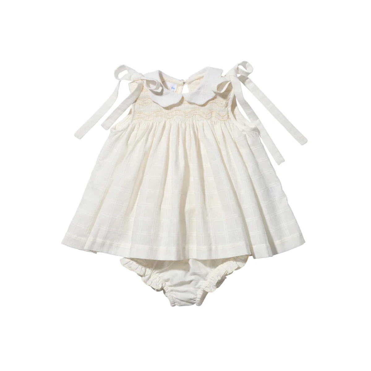 Front view of Olive baby dress in cream windowpane with scalloped collar, smocking, tie shoulder straps, and bloomers