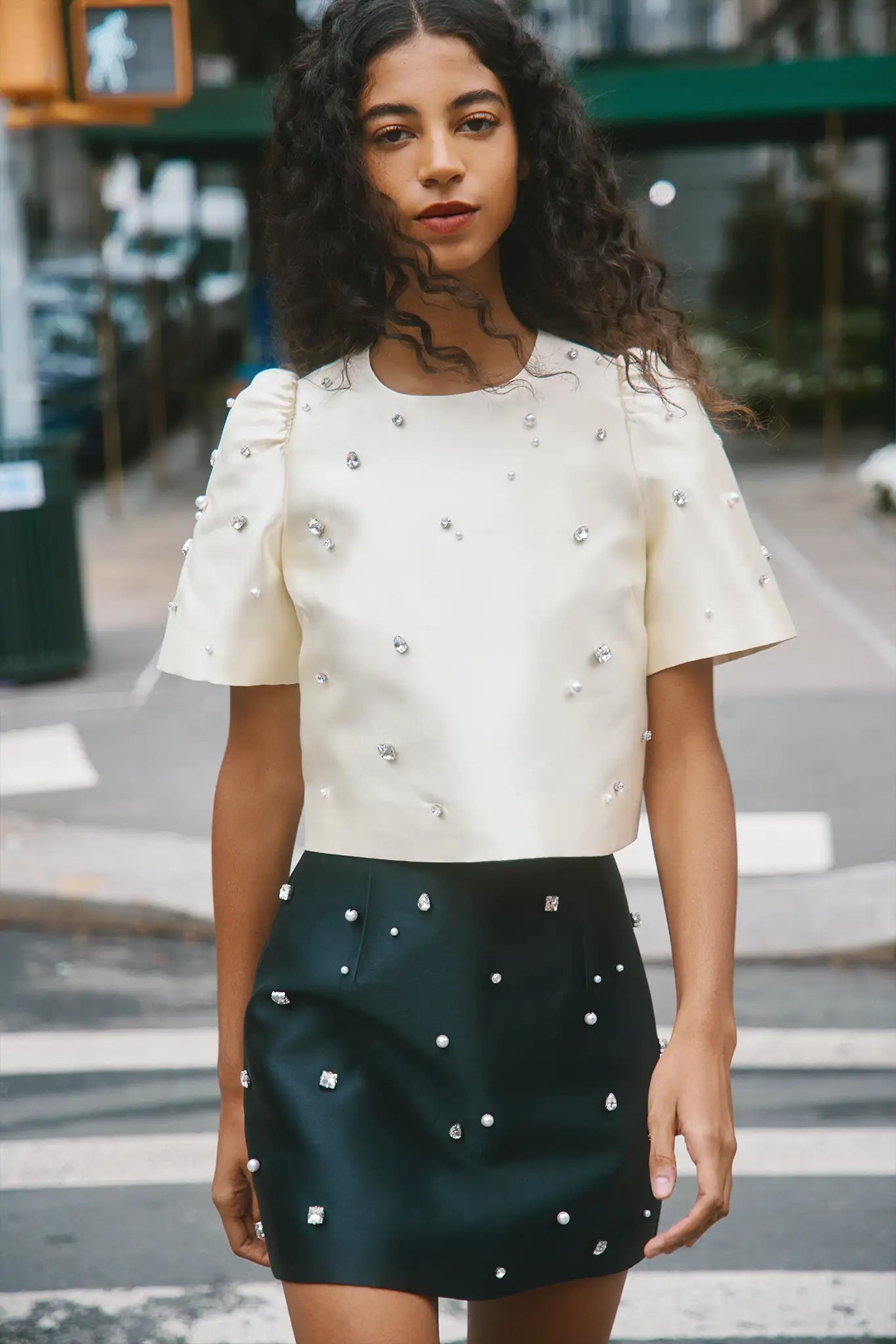 The Britt Skirt is a duchess satin black mini, hand embroidered with pearl and rhinestone detailing.