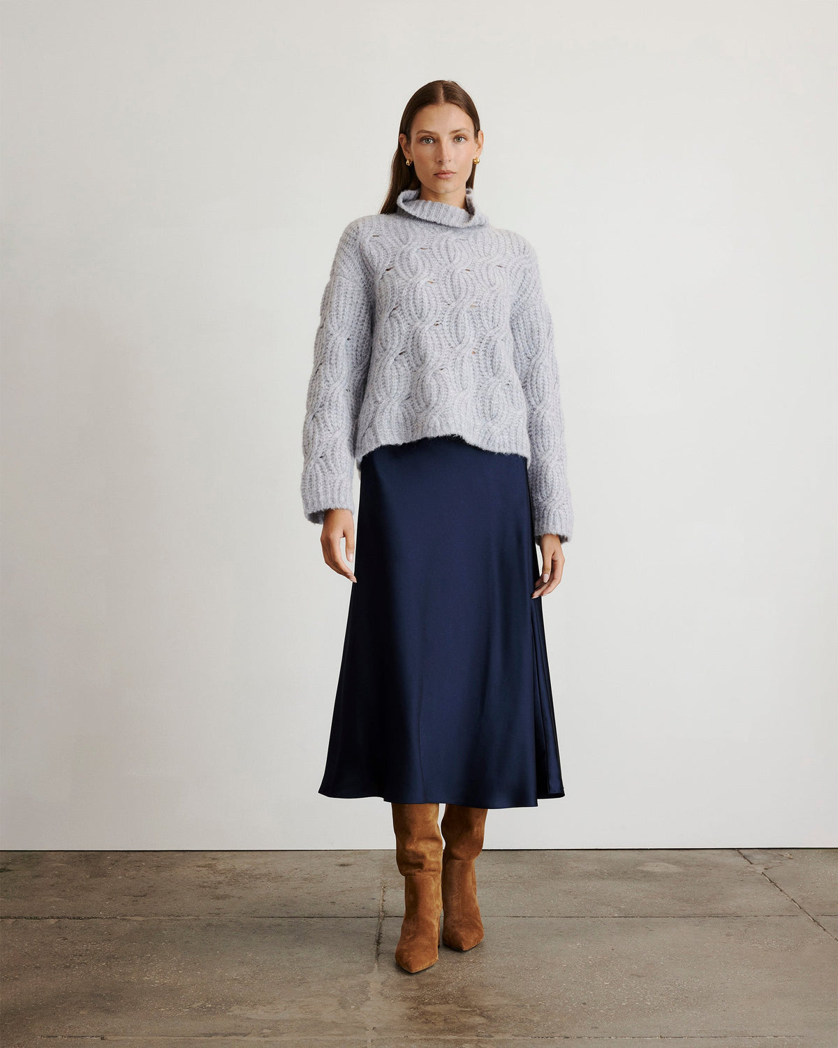 Front view of Opaline Sweater in Grey Sky showcasing fuzzy cable knit and turtleneck on model against studio wall