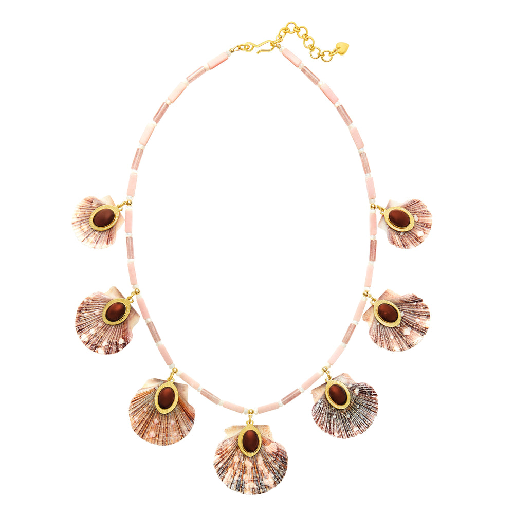 Top view of Ophelia Necklace showing seven scallop shells with garnet centers and pink opal beads on white background