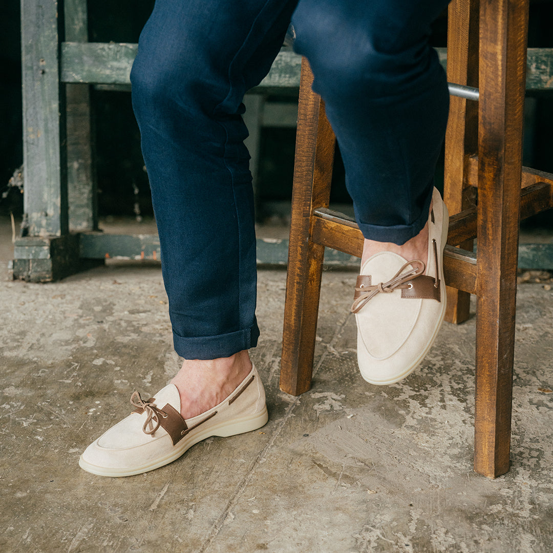 Side view of Men’s Sandstone Suede Barca Yacht Loafer showcasing suede upper and lacing beside a wooden chair