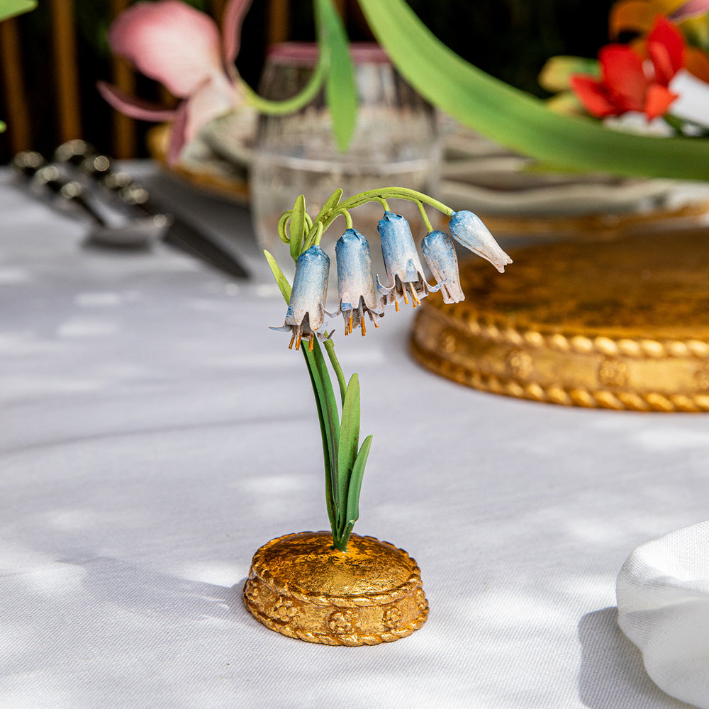 Front view of Meadow Walk Bluebell place card holder showing hand-painted bluebell flowers and gilded base on a white tablecloth