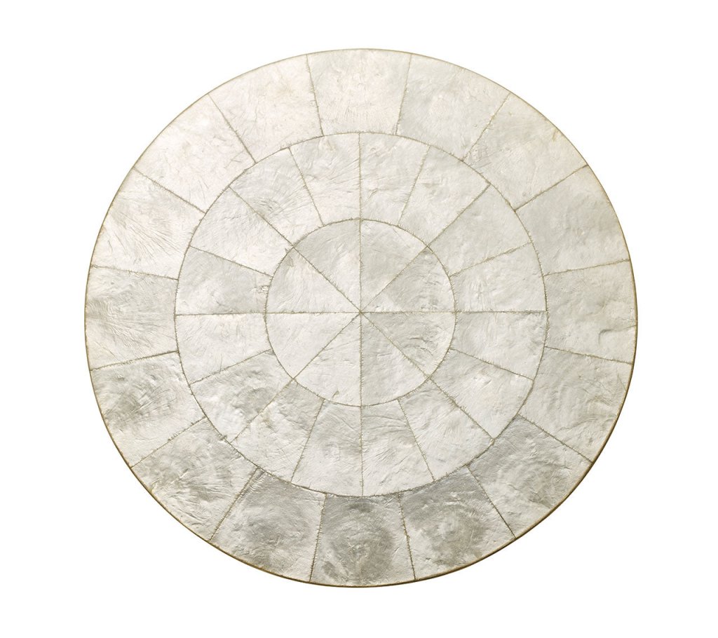 Top view of natural round capiz shell placemat showcasing concentric shell segments on a white background