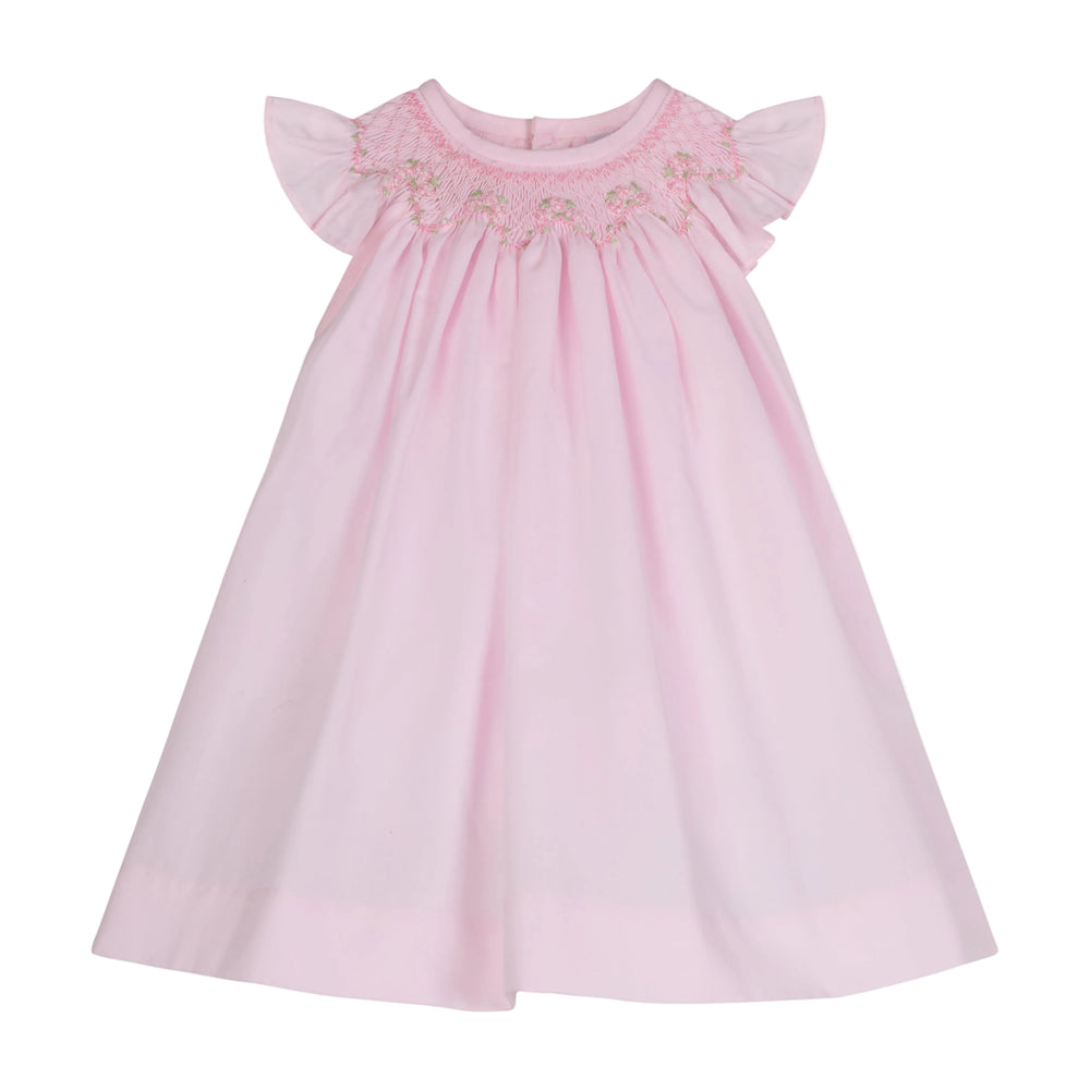 Front view of Manuela dress in light pink with smocked embroidered neckline, flutter sleeves, and A-line silhouette on white