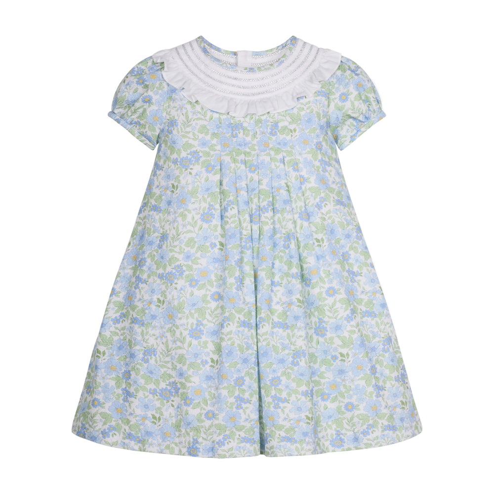 Front view of Lola Dress showcasing white ruffled round collar, front pleats, and pale blue floral A-line silhouette on white background