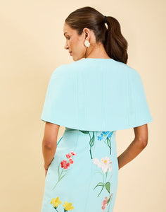 Promenade Embroidered Capelet in Blue Waltz moire with hand-sewn floral embroidery, crew neckline, and hook-and-eye closure.