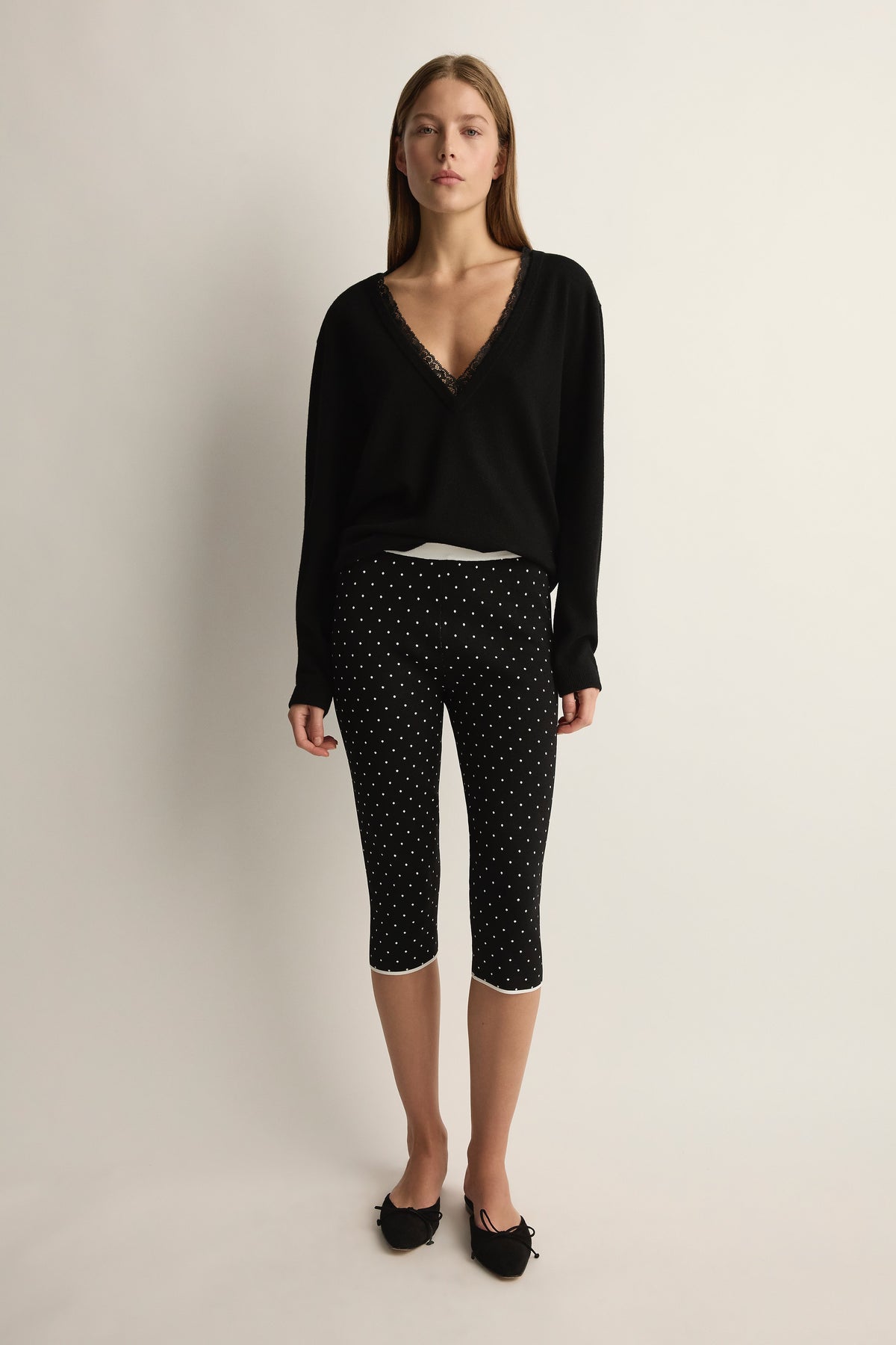 Front view of Michalla Capri in black and white polka dot showcasing cropped fit on model with neutral studio background
