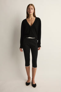 Front view of Michalla Capri in black and white polka dot showcasing cropped fit on model with neutral studio background