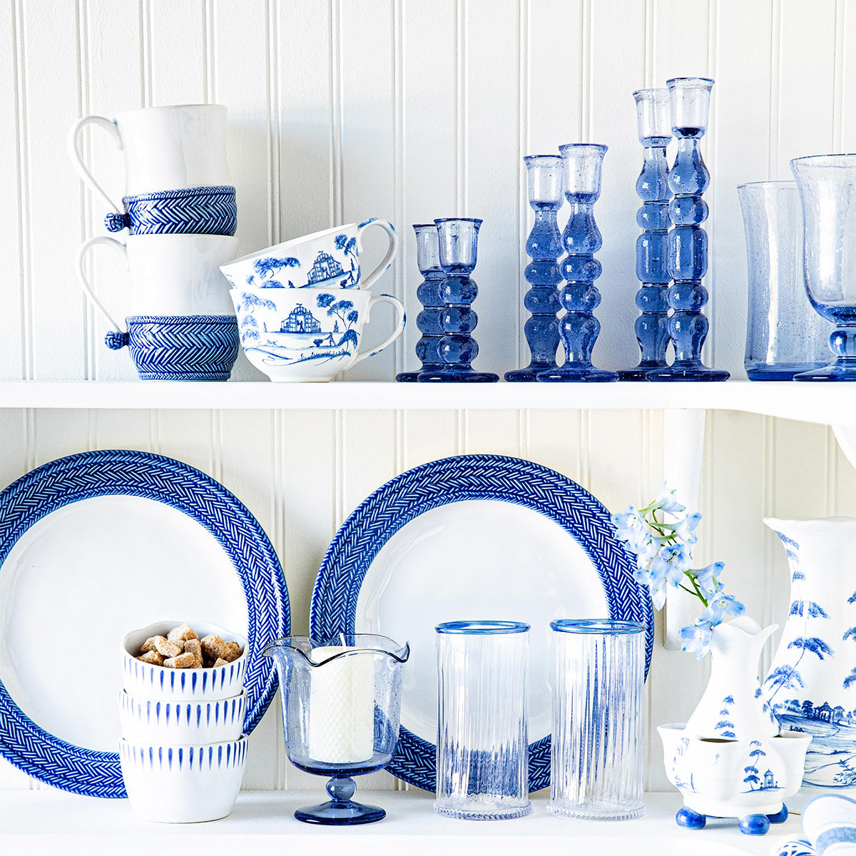 Lifestyle view of Provence 7 inch Candlestick set of 2 in Chambray showcasing mouth blown glass with blue and white tableware
