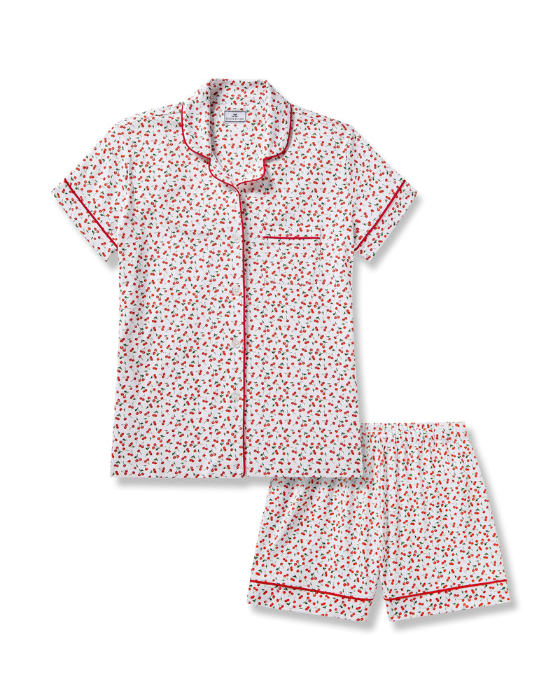 The Petite Plume Womens Pima Short Sleeve Short Set in Cherry Orchard features a white jersey knit with a cherry print, red piped collar, chest pocket, and matching shorts with an elastic waistband.