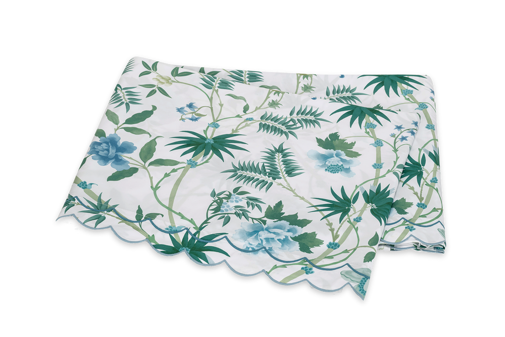 Angled view of Palmyra Flat Sheet showcasing palm fronds, botanical blooms, and double-scallop embroidery