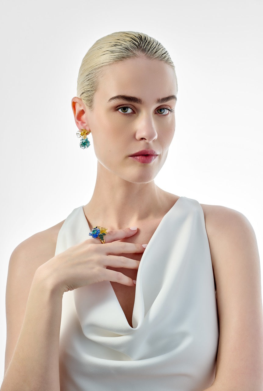 Side view of Paraiba Petunia drop earrings worn by model showing blue-green glass drops and gold floral studs on white