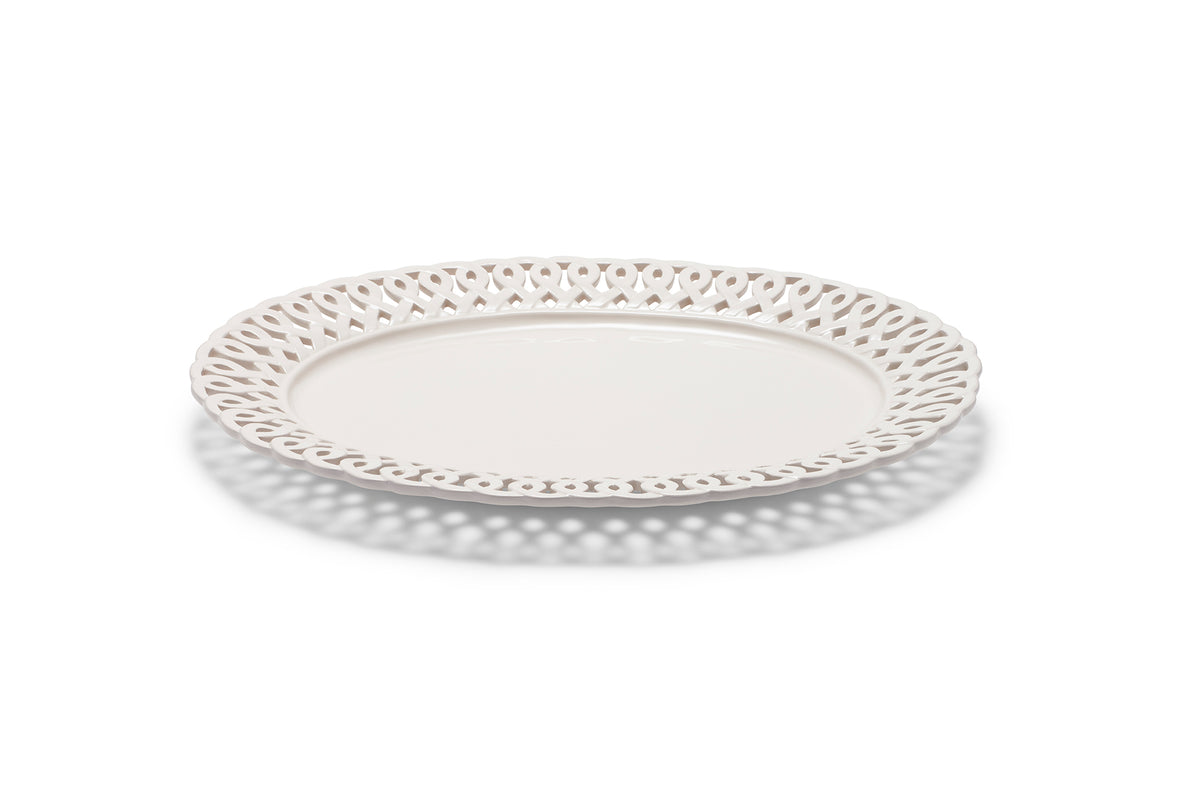 Angled overhead view of Paulette Oval Platter in white showing pierced decorative rim and glossy ceramic center on white