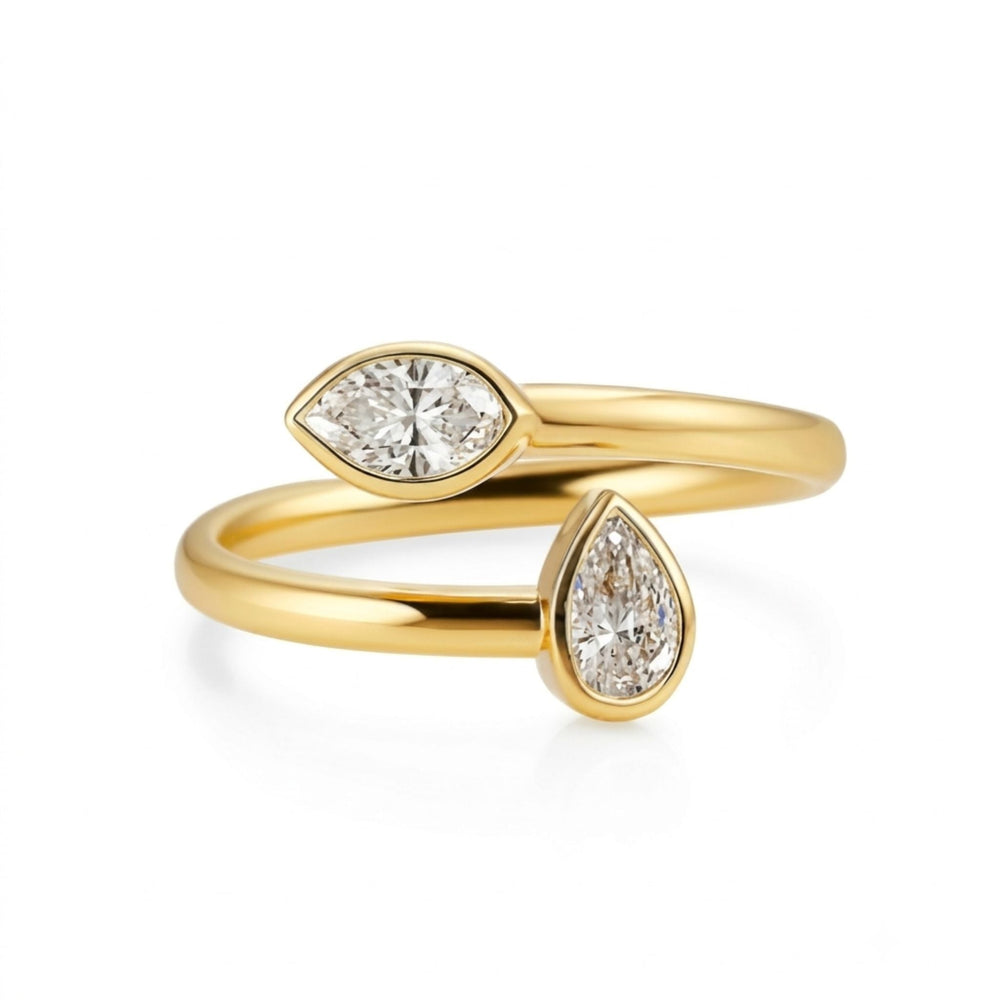 The Toi et Moi Bezel Set Marquise and Pear Shape Diamond Wraparound Ring in Yellow Gold features a gold open band with VS-SI clarity marquise and pear-cut diamonds on each end, all set in lustrous 18k yellow gold.