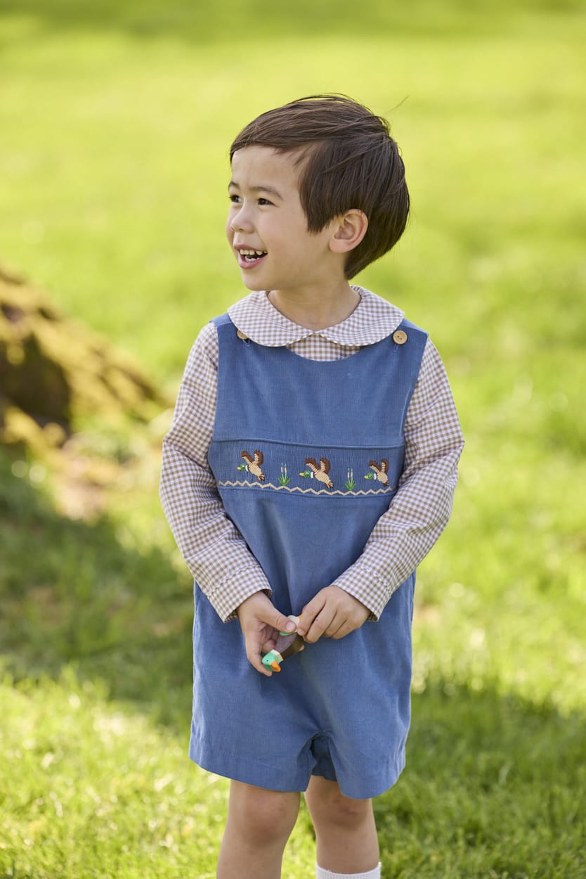 Little English traditional children's clothing.  Khaki Gingham peter pan shirt for toddler boys paired with stormy blue corduroy john john with flying mallard smocking across chest. 