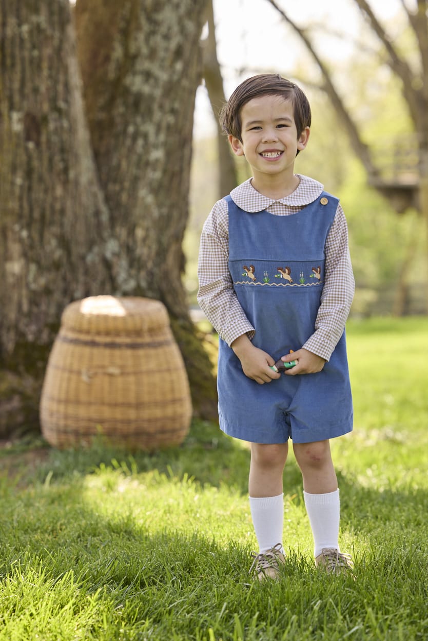 Little English traditional children's clothing.  Khaki Gingham peter pan shirt for toddler boys paired with stormy blue corduroy john john with flying mallard smocking across chest. 