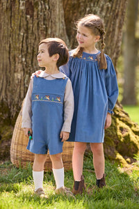 Little English traditional children's clothing.  Khaki Gingham peter pan shirt for toddler boys paired with stormy blue corduroy shortall with flying mallard smocking across chest. Long sleeve stormy blue corduroy dress with flying mallard collar around the neckline for little girls.
