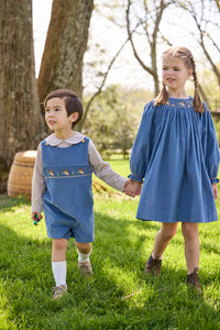 Little English traditional children's clothing.  Khaki Gingham peter pan shirt for toddler boys paired with stormy blue corduroy shortall with flying mallard smocking across chest. Long sleeve stormy blue corduroy dress with flying mallard collar around the neckline for little girls.
