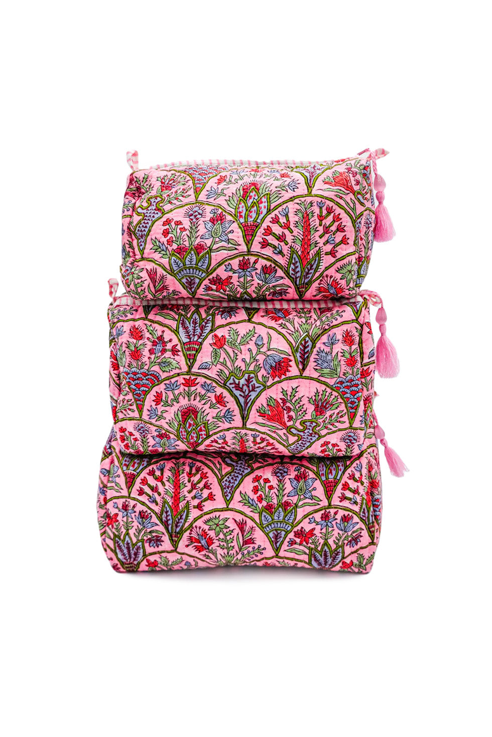 Front view of three stacked Pink Arch toiletry bags showcasing pink block-printed floral pattern and tassel zipper pulls on white background
