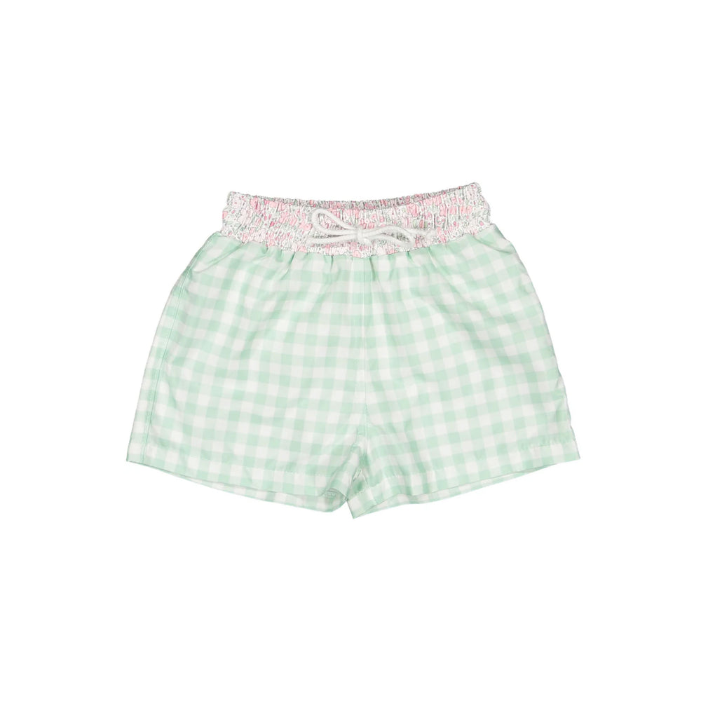 Flat lay of children’s trunks with smocked pink ditsy floral waistband and mint gingham shorts on white background