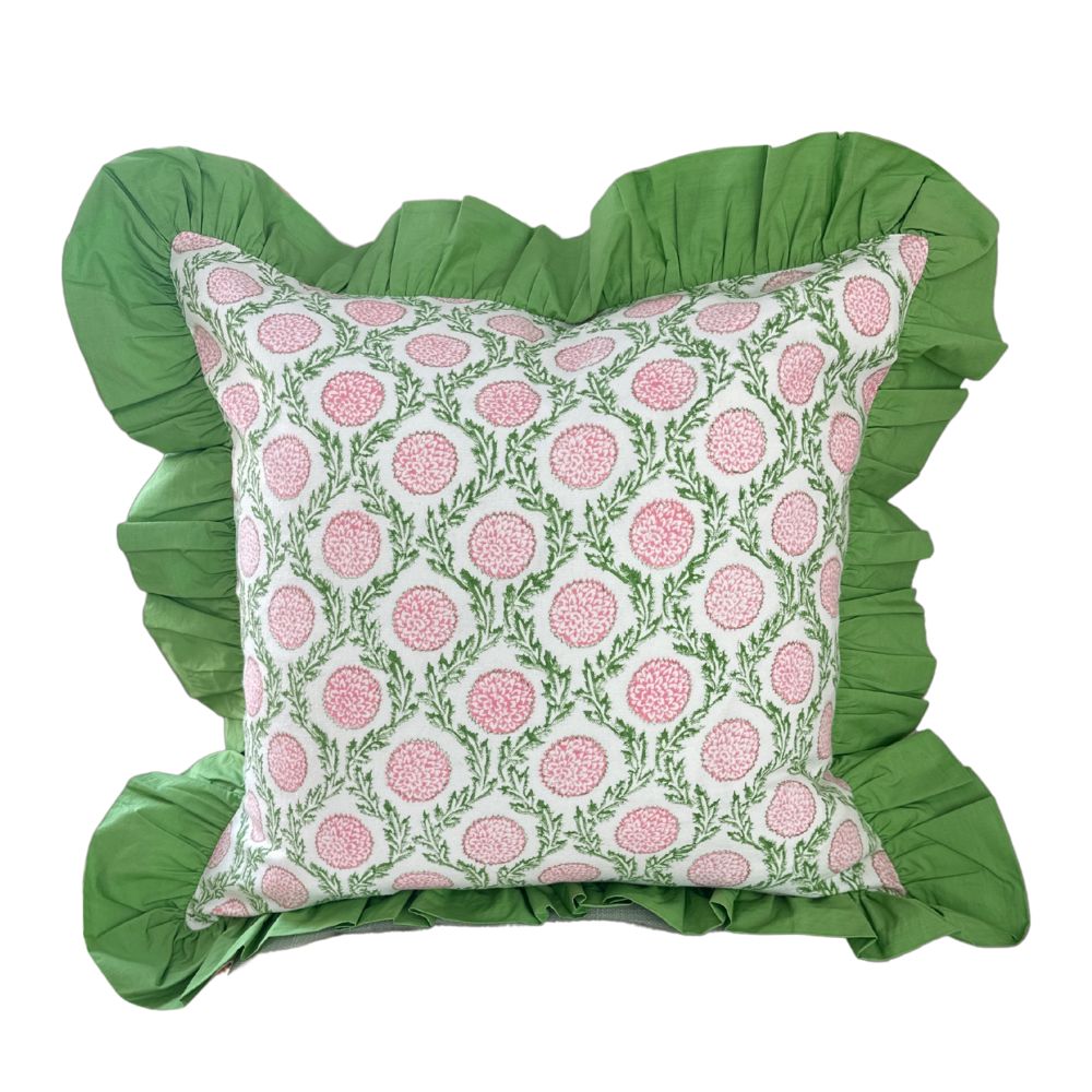 Decorative pillow with pink floral pattern and green ruffled edges on a white background