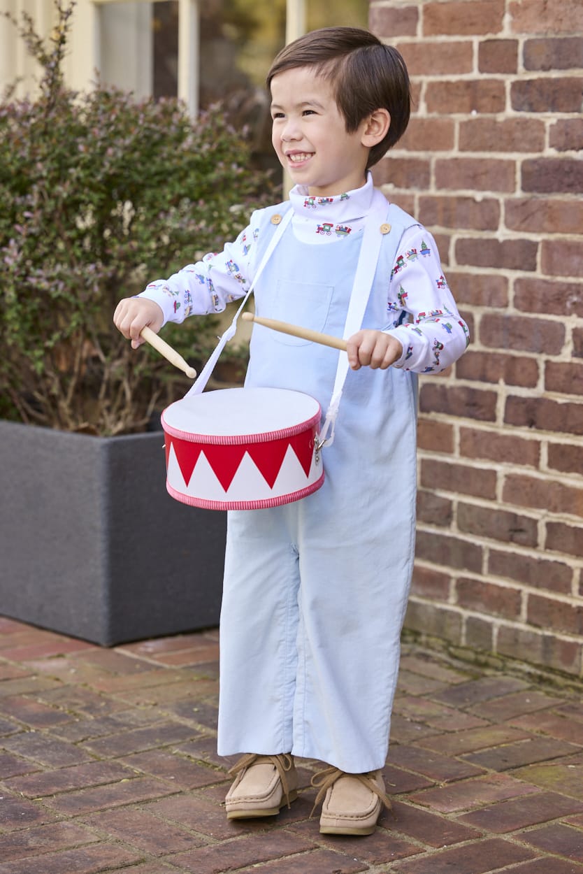 Little English classic children's clothing. White knit turtleneck with holiday train print layered under light blue corduroy Campbell Overall. Holiday outfit for toddler boys.
