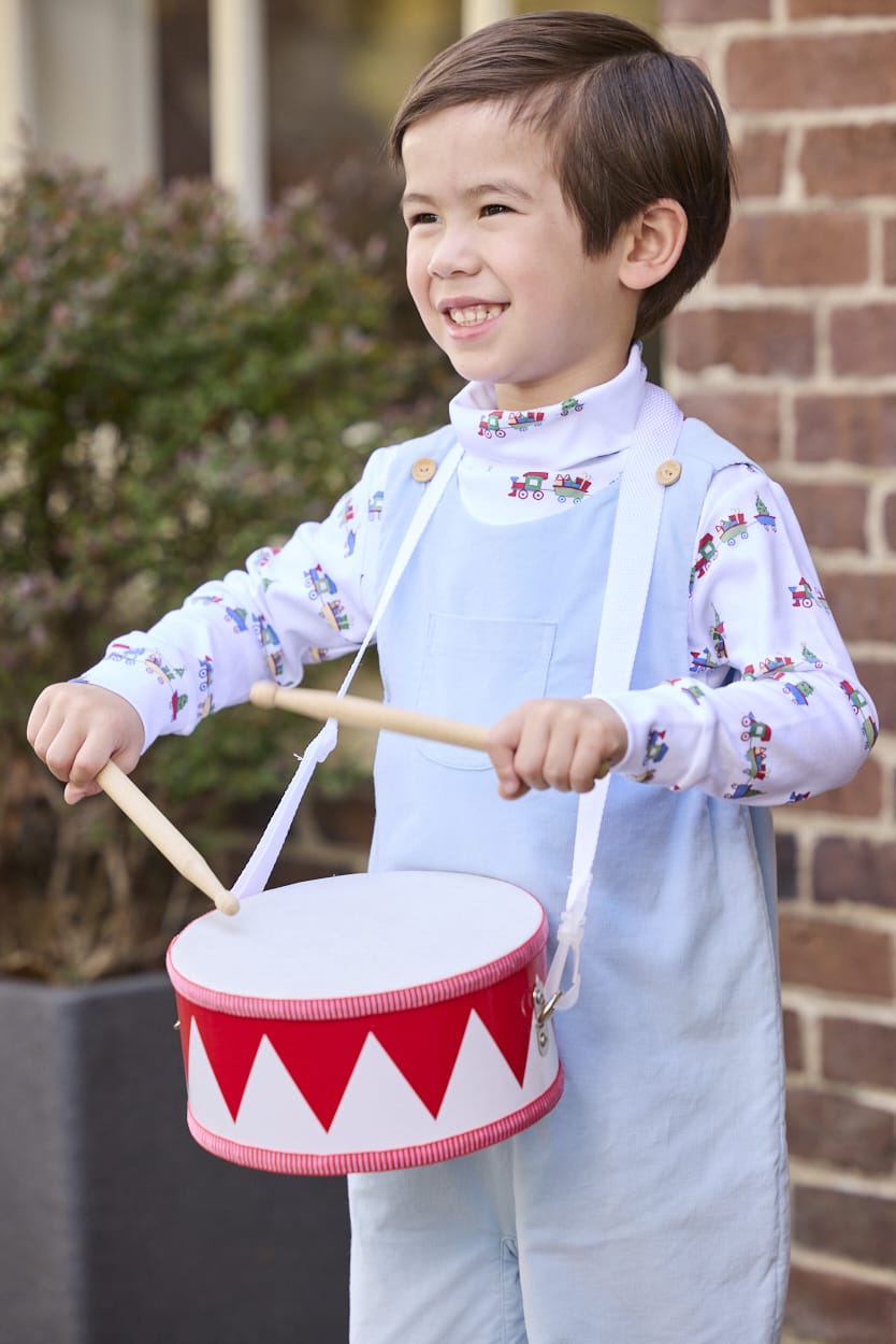 Little English classic children's clothing. White knit turtleneck with holiday train print layered under light blue corduroy Campbell Overall. Holiday outfit for toddler boys.
