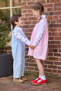 Little English classic children's clothing. White knit turtleneck with holiday train print layered under light blue corduroy Campbell Overall. White knit turtleneck with holiday present print layered under light pink corduroy Madison Jumper. Holiday outfit for little boys and girls.