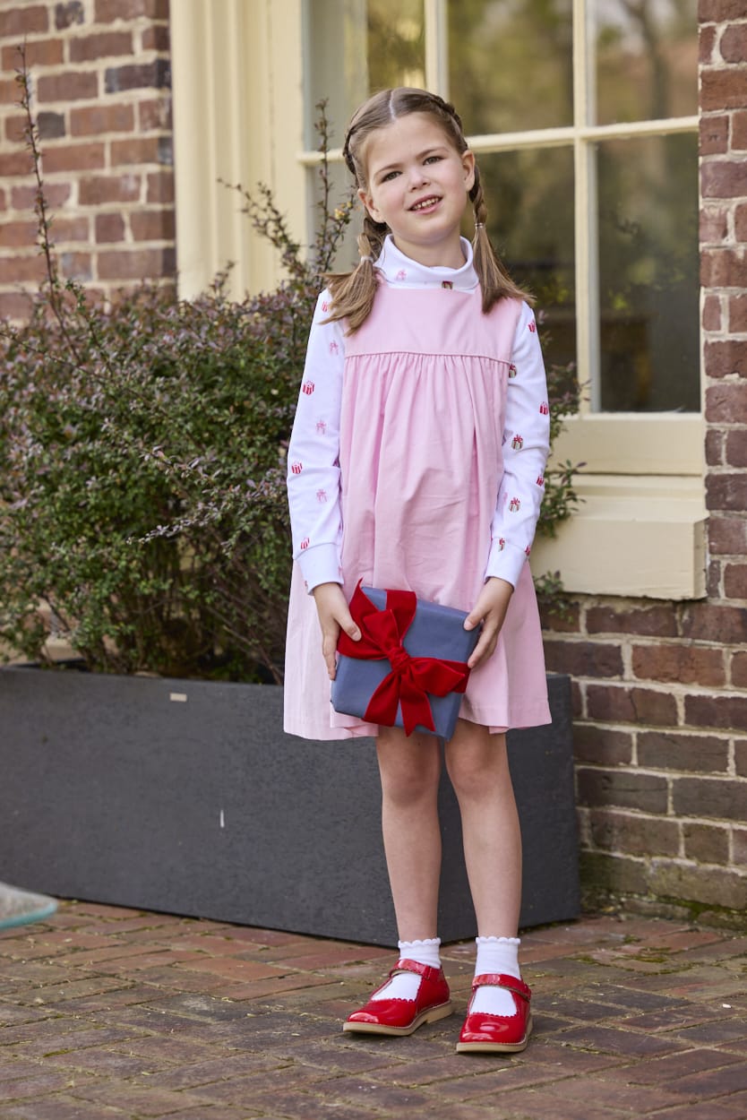 Little English classic children's clothing. White knit turtleneck with holiday present print layered under light pink corduroy Madison Jumper. Holiday outfit for little boys and girls.