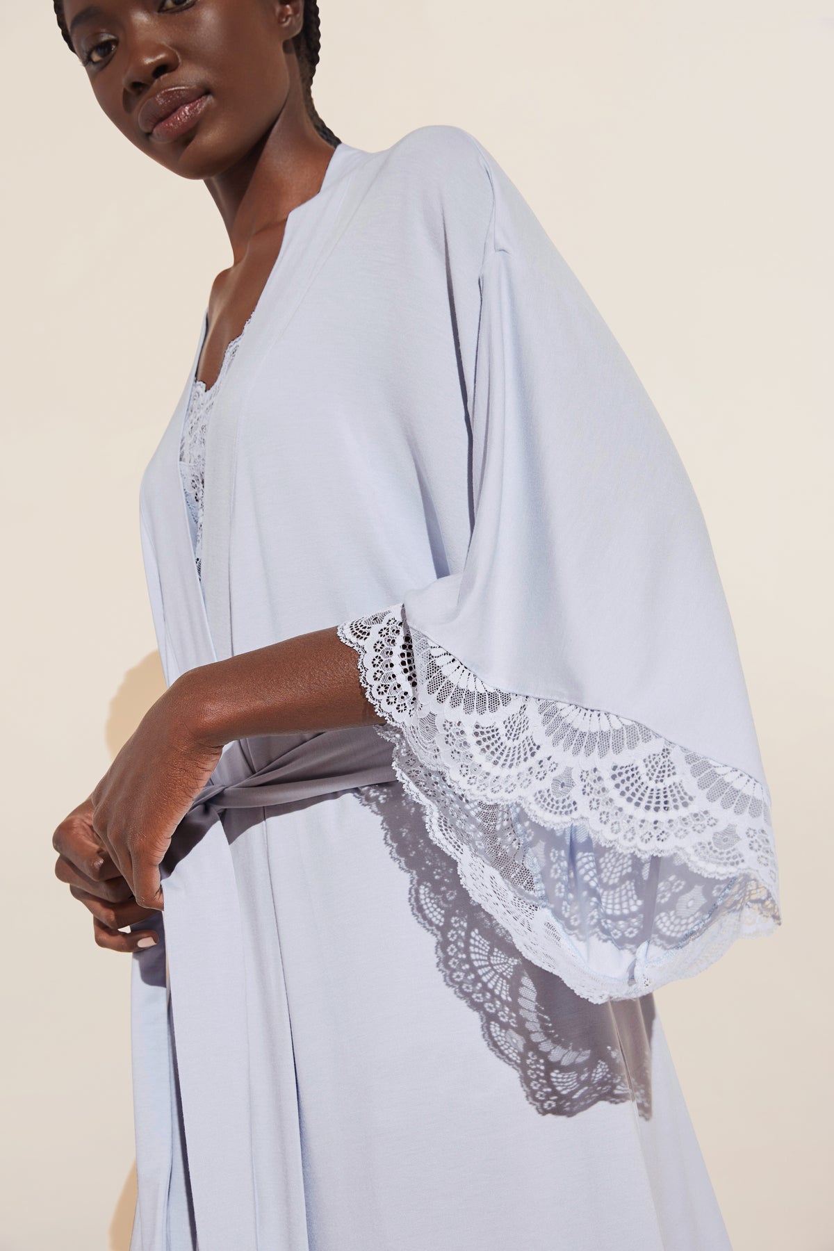 Three-quarter view of Mariana Short Robe showcasing ice blue fabric, lace-trimmed kimono sleeves and attached belt against a neutral background