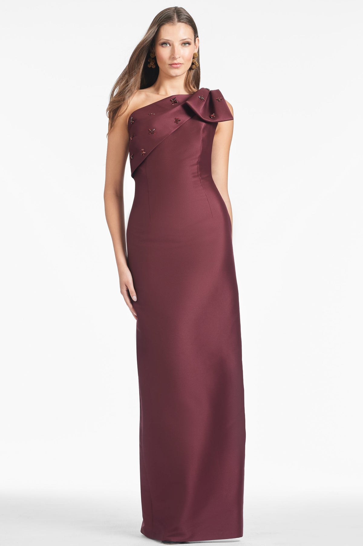 Front view of Olivia Gown in Malbec showcasing figure-skimming one-shoulder styling and embellished bow on white background