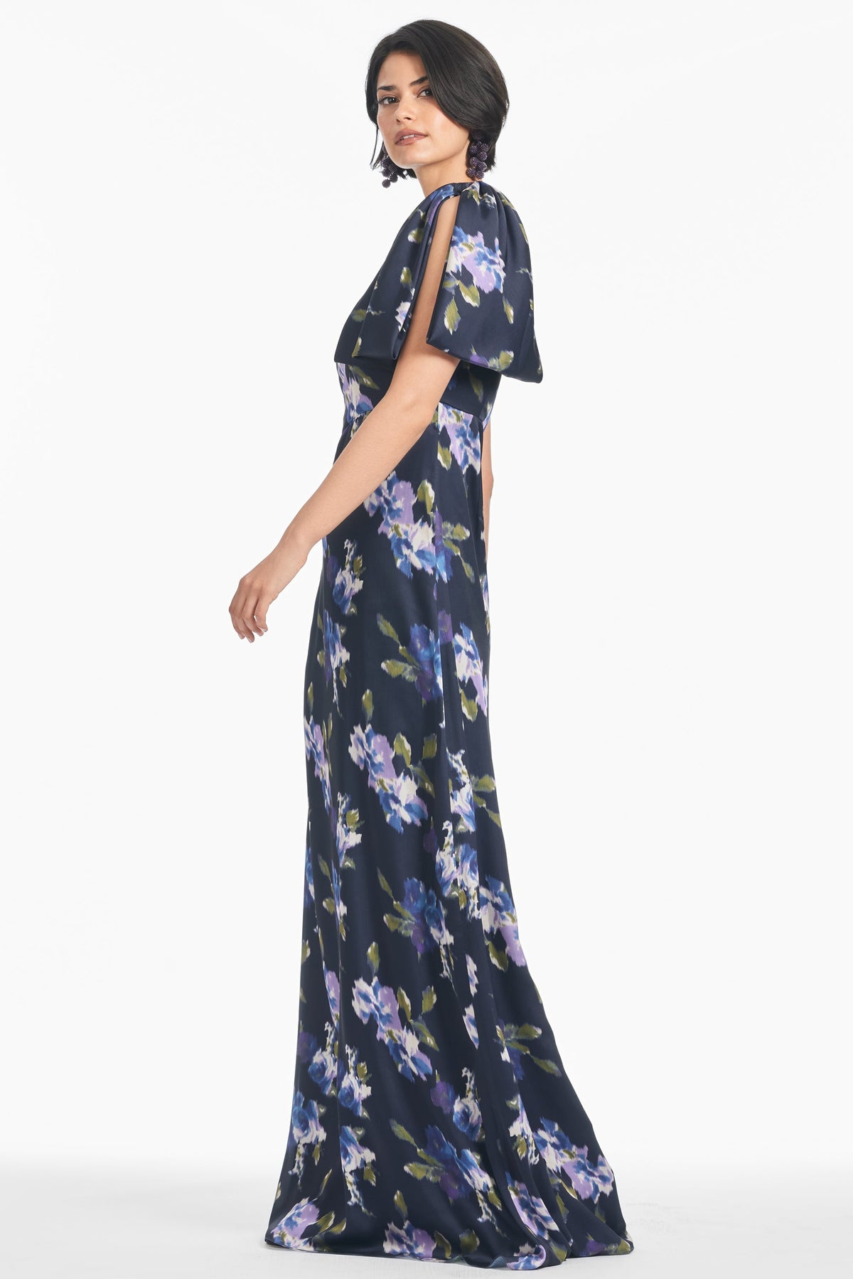 Side view of Chelsea Gown in Midnight Corsage showcasing the floral print and hand-tucked shoulder bow against a white background