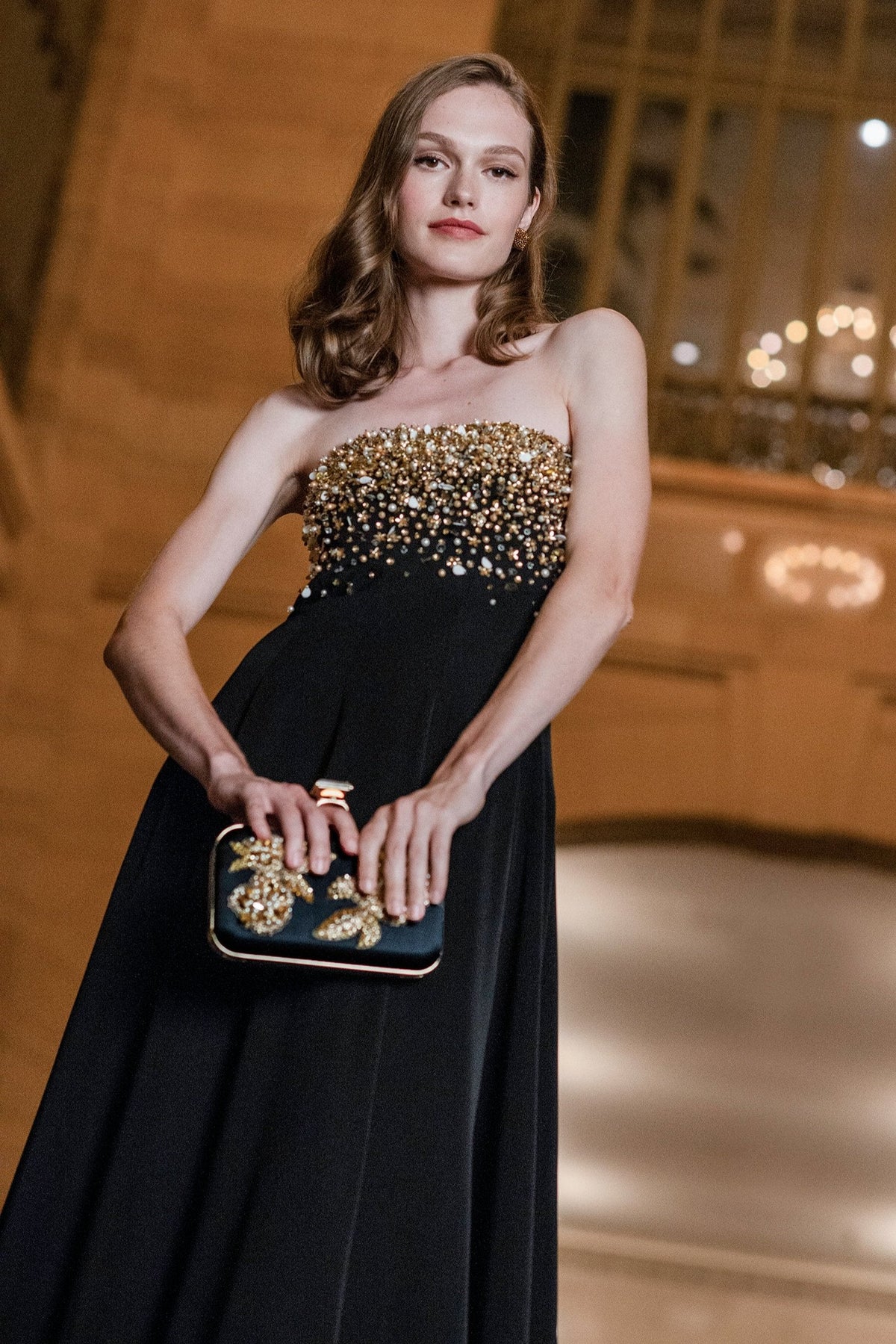 Front view of Bettany Gown in Black showcasing gold embellished strapless bodice on model indoors